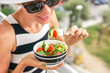 © Leart - Woman eating salad. Beautiful woman eating salad with a view of the city
