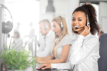 Wall Mural - Call center worker accompanied by her team.