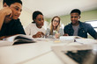 © Jacob Lund - Students studying with books in classroom