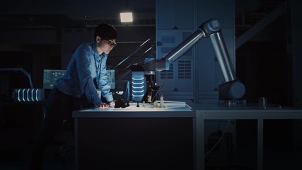 Leinwandbilder - Japanese Development Engineer is Testing an Artificial Intelligence Interface by Playing Chess with a Futuristic Robotic Arm. They are in a High Tech Modern Research Laboratory with Low Key Light.