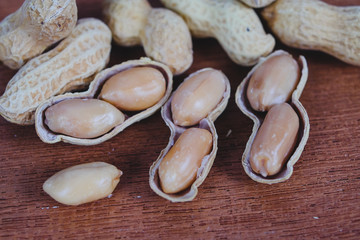 Wall Mural - Peanuts in shells on wood table background.