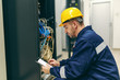 © dusanpetkovic1 - Engineer using tablet and repairing electricity in plant.