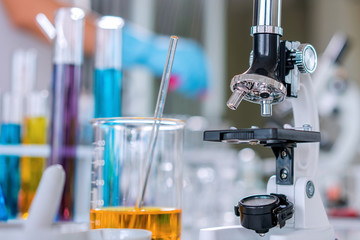 scientist with equipment and science experiments, laboratory glassware containing chemical liquid fo