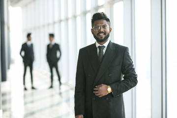 Happy indian business man in suit in modern office