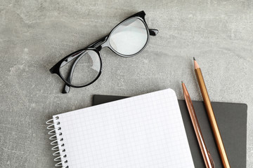 Wall Mural - Copybooks, glasses and pencil on grey table, space for text