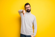 Man With Beard And Turtleneck Showing Thumb Down Sign With Negative Expression
