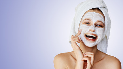 Wall Mural - beautiful young woman applying facial mask on her face. skin care and treatment, spa, natural beauty