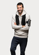 Sport man keeping the arms crossed while smiling over isolated grey background