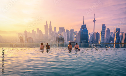 Traveler looking view skyline Kuala Lumpur city in swimming pool on the roof top of hotel at sunrise in Kuala Lumpur, Malaysia Canvas Print