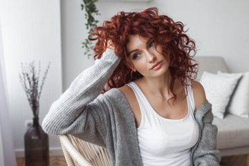 Very attractive young woman close up portrait. Beautiful female indoor. Curly haired lady. Red-haired girl. Redhead with wavy hair.