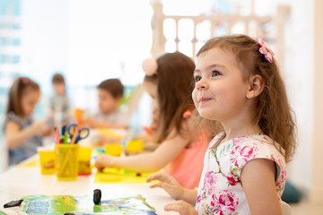 group of preschool kids engaged in drawing and crafts