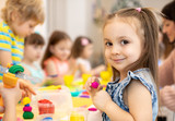 Fototapeta Koty - happy kids doing arts and crafts in daycare centre