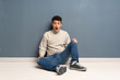 © luismolinero - Young man sitting on the floor with surprise facial expression