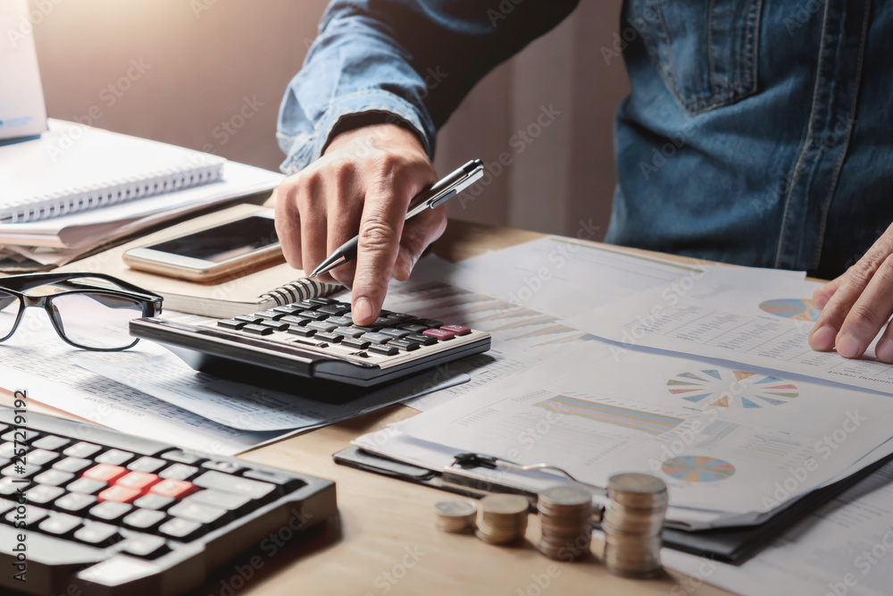 Manager Using Calculator businessman working in office with using a calculator to calculate the ...