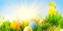 Easter Scene. Beautiful Colorful Eggs In Spring Grass Meadow Over Blue Sky With Sun Border Design