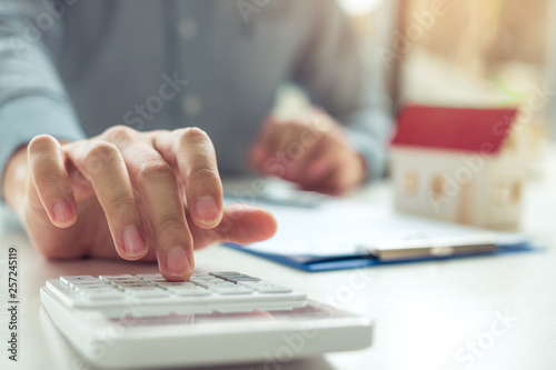Cuadros en Lienzo Home agents are using a calculator to calculate the loan period each month for the customer