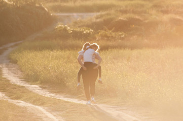 fat adult woman grandmother carry little girl grandchild on her back during sport active leisure outdoors