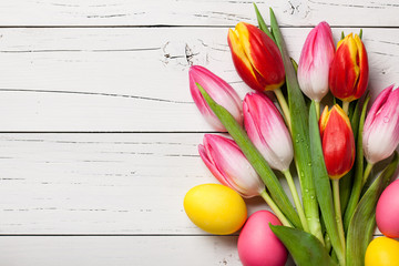 Canvas Print - Fresh colorful tulips and easter eggs on wooden background