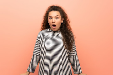 Teenager girl over pink wall with surprise facial expression