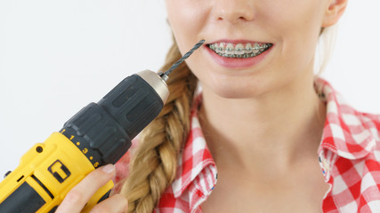 Wall Mural - Woman with braces using drill on her teeth