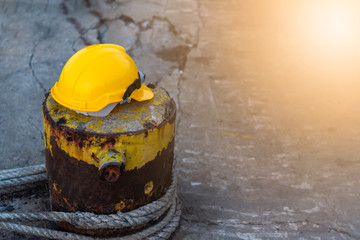 Yellow helmet Put on a steel bar That is attached to the floor, and has a rope tied on the iron bar, to engineering concept.