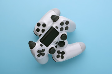 Poster - Two white joystick gamepad, game console on blue colourful trendy modern fashion pin-up background. Computer gaming competition videogame control confrontation concept