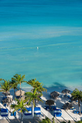 Wall Mural - Typical beach with coconut palms and palm leaf umbrellas to protect yourself from the sun. Palm beach. Aruba