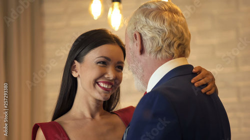 Fotografía Young woman flirting and dancing with old millionaire on date, escort service