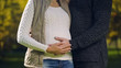 © motortion - Pregnant woman with husband stroking belly, prenatal care, fertility science