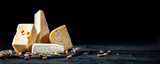 Fototapeta Tulipany - Different kinds of cheese with nuts on dark background, copy space