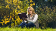 © motortion - Concentrated woman reading scientific book in autumn park, sitting on grass