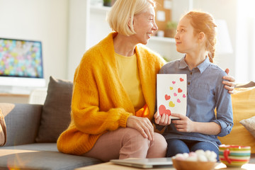 Side view portrait of mature woman hugging teenage daughter and smiling happily on Mothers day, copy space