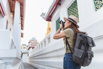 Wall Mural - Asian woman travel Bangkok, Thailand, in beautiful temple during summer season, taking photo by camera