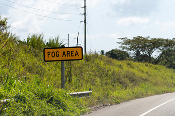 Fog Area road sign/street sign on highway through countryside