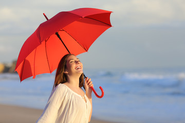 Poster - Excited woman holding red umbrella celebrating success