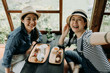 © PR Image Factory - happy japanese friends spending time in Tokyo having fun doing tea ceremony drinking eating cake dessert. women tourist taking selfie in wooden traditional house. smiling female making self portrait.