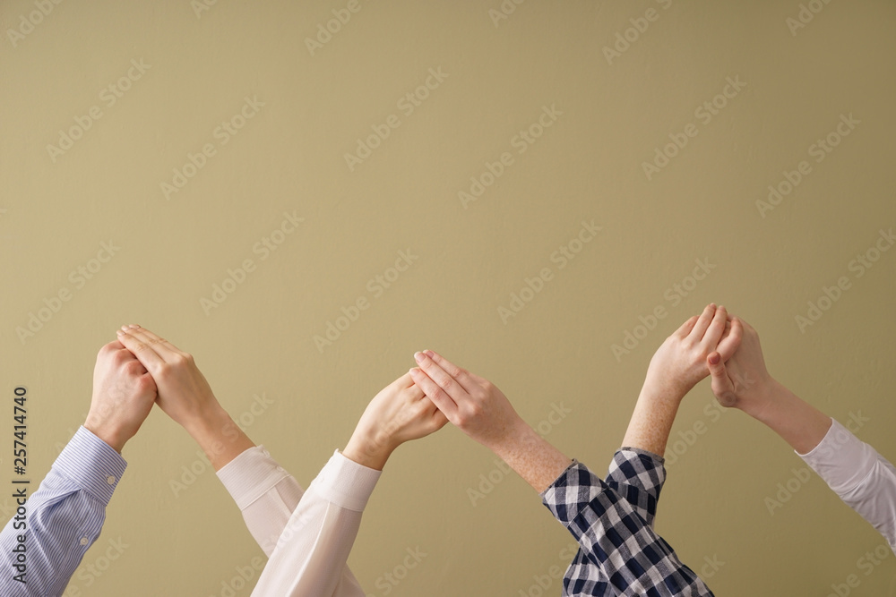 Group of people holding hands on color background. Concept of unity