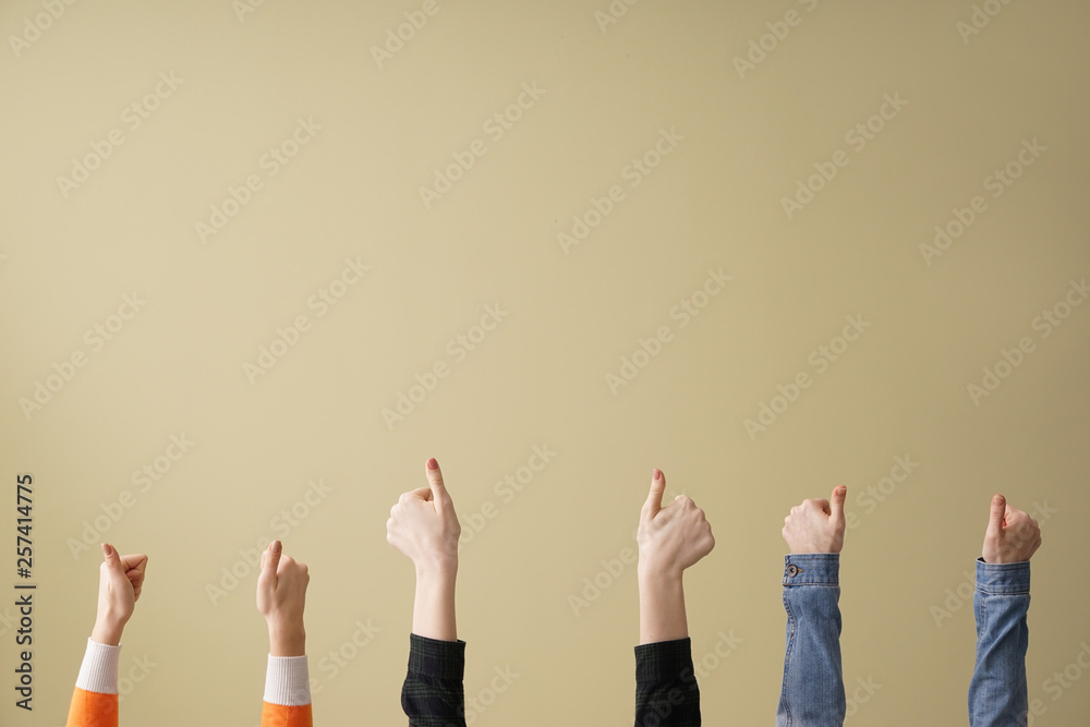 Hands of people showing thumb-up on color background