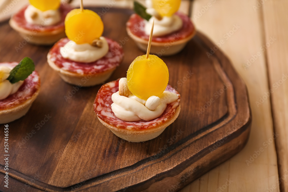 Tasty canapes on wooden board