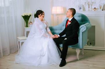 wedding photoshoot in the Studio. the bride and groom posing. groom with a red tie and black business suit. the bride in a white lush dress