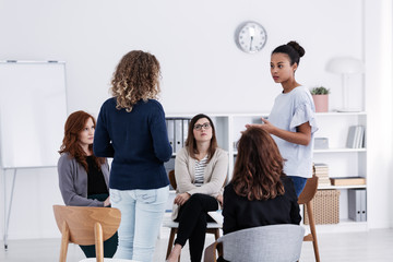 Wall Mural - Group of young women talking sitting in a circle. Psychological support concept