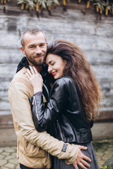 Tender romantic cheerful happy couple walking outdoors hugging and kissing each other outdoors in park. Relationships, love, hipster couple concept