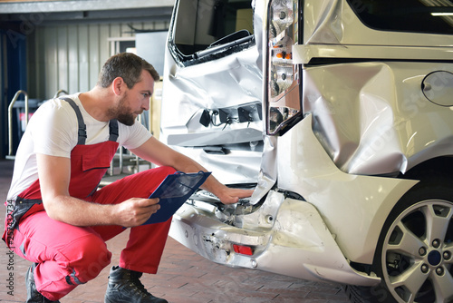 Fotomural Begutachtung Unfallwagen in einer Autowerkstatt durch Mechaniker // Inspection o