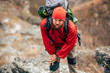 © iuricazac - Image of tired hiker man hiking in mountains dressed in red clothes exploring new places. Traveler bearded male trekking and mountaineering during his journey. Travel, people, sport, lifestyle concept