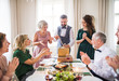 © Halfpoint - A mature man with friends and family opening presents on a birthday party.