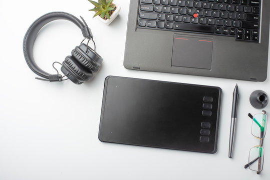Desktop designer and creative retoucher with a graphics tablet, laptop, glasses. Design, flat lay