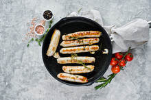 Assorted Fried Sausages In A Frying Pan, Pork, Beef, Chicken, Turkey. Gray Background, Top View