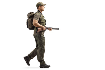 Wall Mural - Hunter walking and holding a shotgun