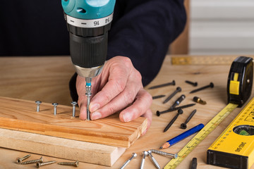 Carpenter with electric screwdriver. carpenter at handmade work