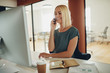 © Flamingo Images - Smiling young businesswoman talking on her cellphone in an offic